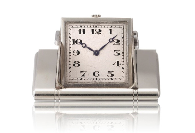 1928 - Montre de poche "surprise". Or gris 18K, cadran argenté, chiffres arabes noirs. Ouverture des volets par pression sur les flancs de la boîte.